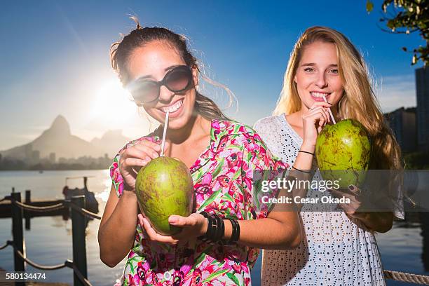 ragazze a bere acqua di cocco - acqua di cocco foto e immagini stock