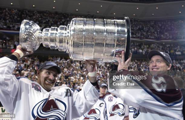 Ray Bourque of the Colorado Avalanche and teammate Patrick Roy raise the Stanley Cup after they beat the New Jersey Devils 3-1 in game seven of the...