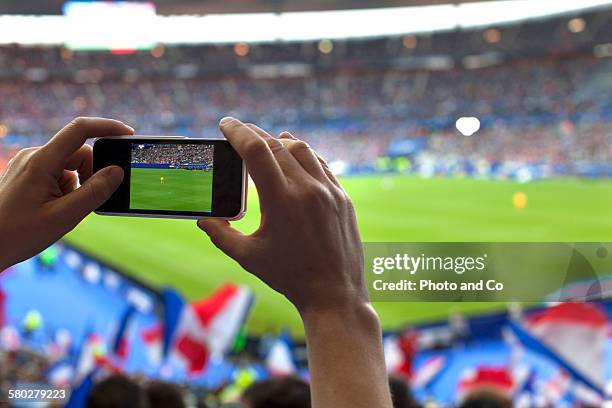 french football fan taking cell phone picture - soccer stadium stock-fotos und bilder