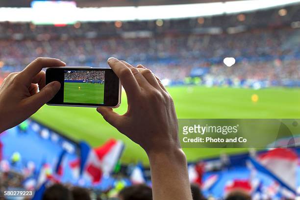 french football fan taking cell phone picture - hand fan fotografías e imágenes de stock