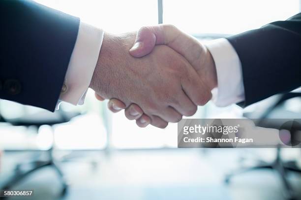handshake in an office - handshake stock pictures, royalty-free photos & images