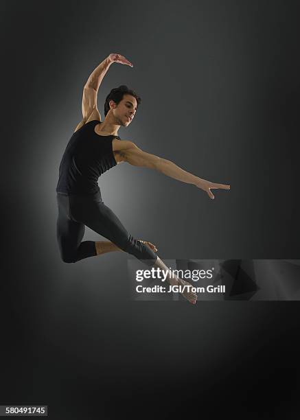 hispanic ballet dancer leaping in mid-air - balletttänzer stock-fotos und bilder
