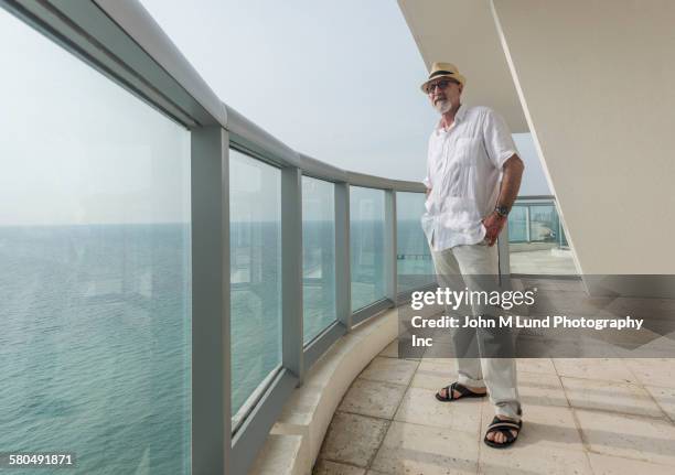 man overlooking ocean from balcony - looking over balcony stock pictures, royalty-free photos & images