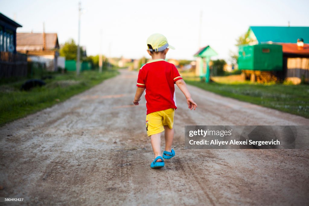 Mari boy walking on dirt path
