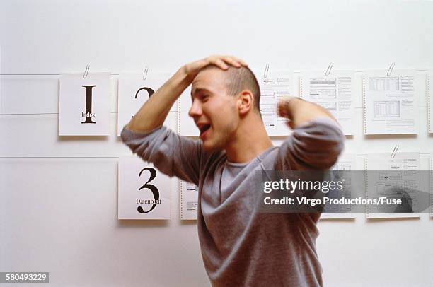 young man holding his head in despair - bald man crying stock pictures, royalty-free photos & images