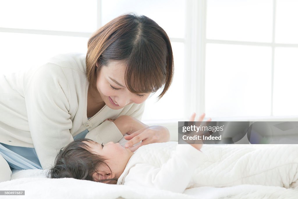 Mother looking at lying baby