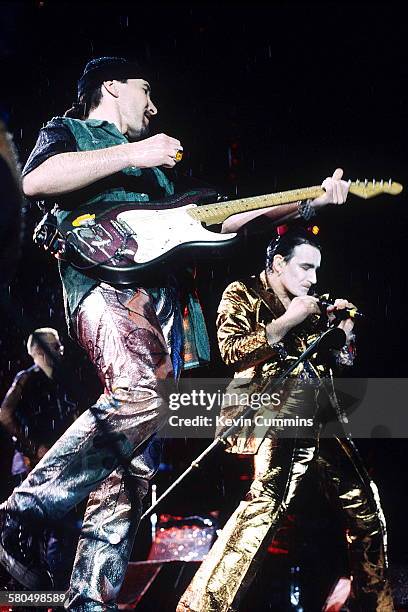 Guitarist The Edge and Singer Bono, in his stage persona of Mr. MacPhisto, performing with Irish rock group U2 on their 'Zoo TV' tour, 1992.