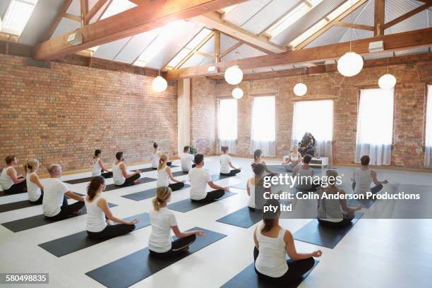 instructor leading students in yoga class - learn to lead stock pictures, royalty-free photos & images