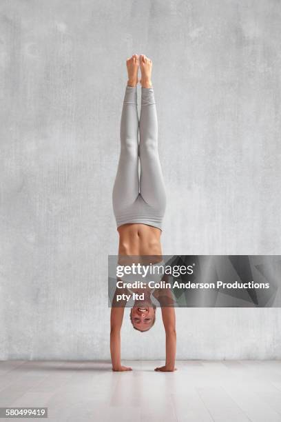 caucasian woman practicing yoga in studio - hacer el pino fotografías e imágenes de stock