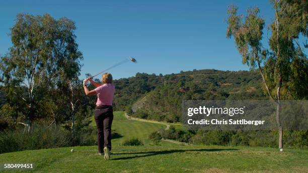 caucasian woman teeing off on golf course - teeing off stock pictures, royalty-free photos & images