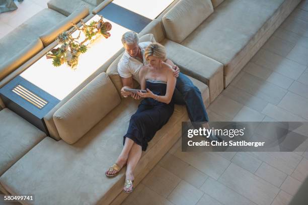 high angle view of caucasian couple using digital tablet in hotel lobby - couple travel tablet stock-fotos und bilder