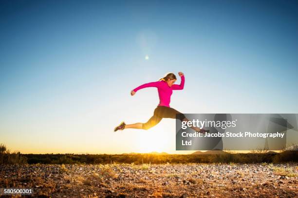 caucasian woman running in remote field - 2014 track field stock pictures, royalty-free photos & images