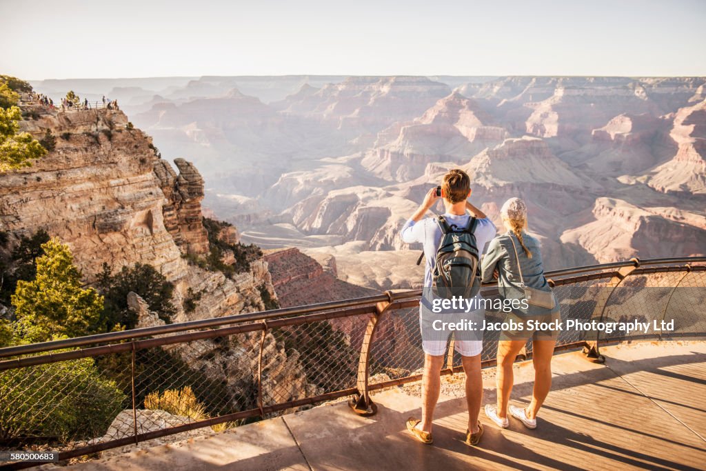 Caucasian couple photographing Grand Canyon, Arizona, United States