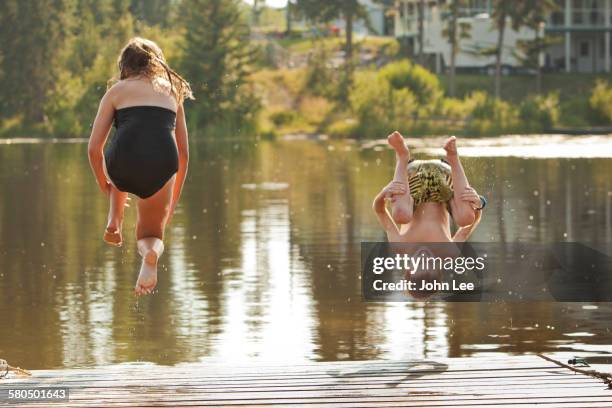 caucasian children jumping into lake - cannonball diving stock pictures, royalty-free photos & images