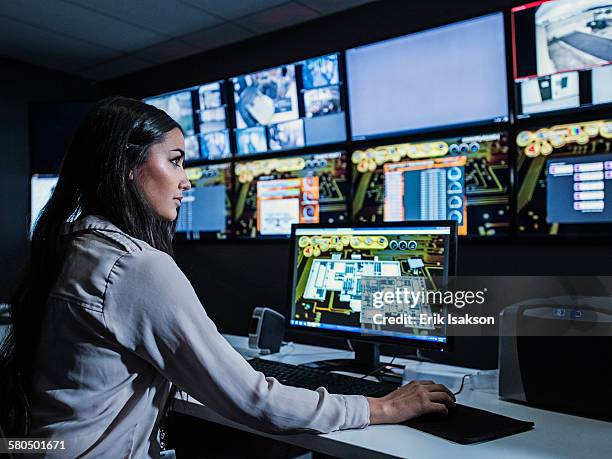 mixed race security guard watching monitors in control room - one woman only videos stock pictures, royalty-free photos & images