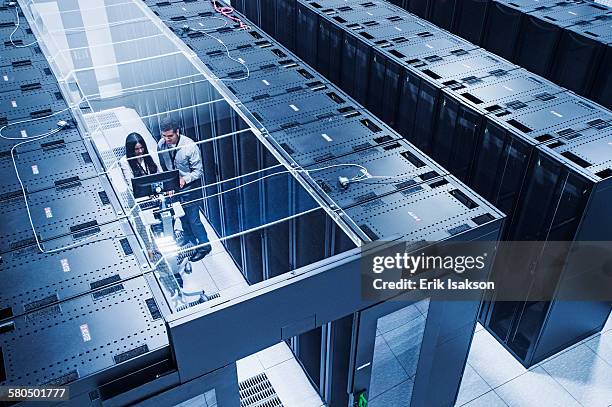 high angle view of technicians working in server room - server bildbanksfoton och bilder