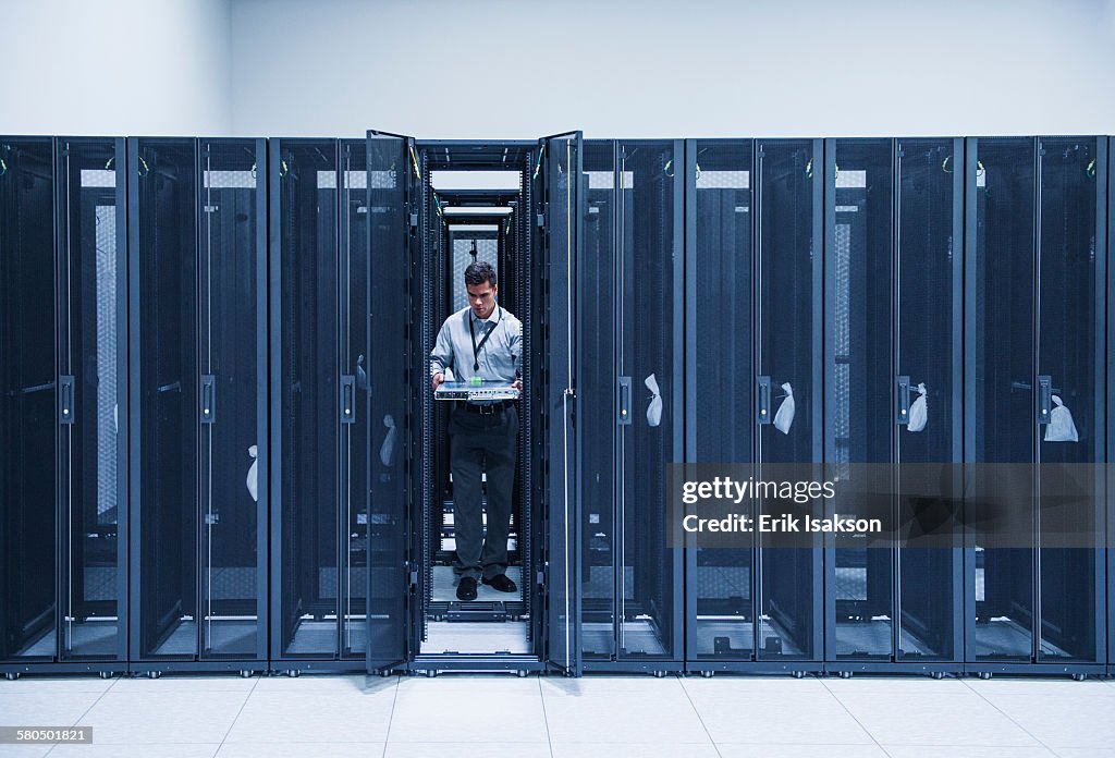 Hispanic technician working in server room