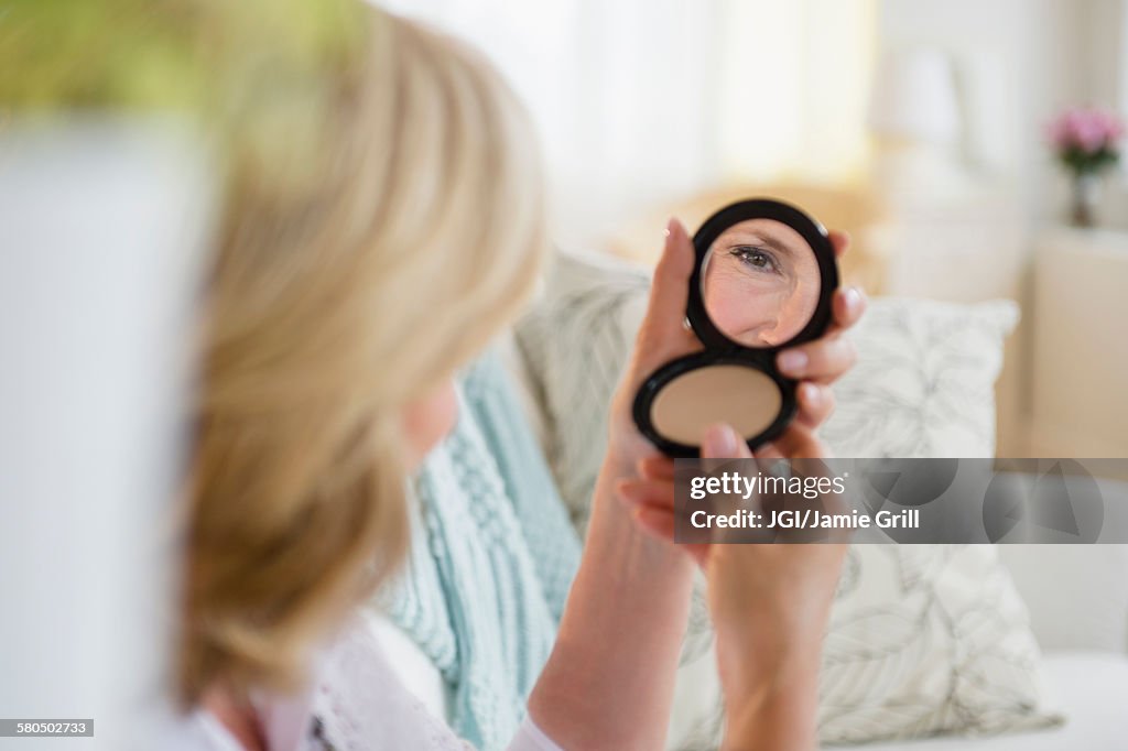 Caucasian woman admiring herself in mirror