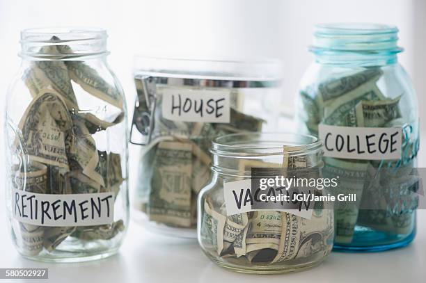 close up of savings jars with money - money jar stock-fotos und bilder