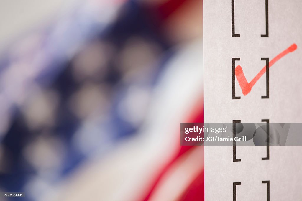 Close up of voting ballot near American flag