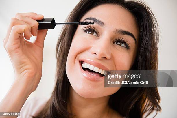 close up of woman applying makeup - mascara stockfoto's en -beelden