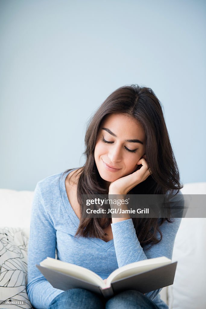Close up of woman reading book on sofa
