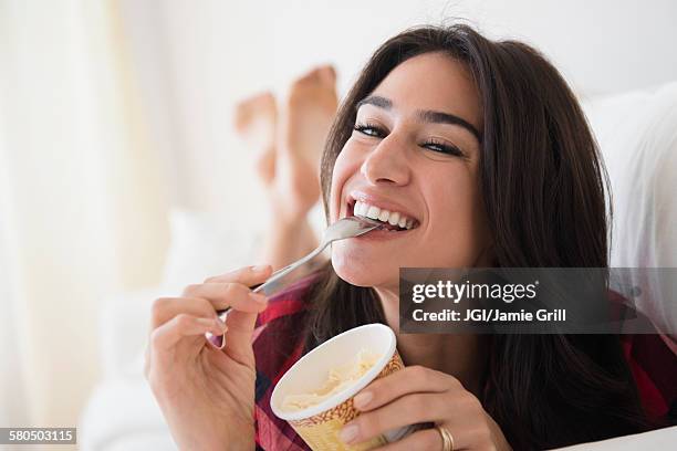 close up of woman eating ice cream on sofa - woman ice cream stock pictures, royalty-free photos & images