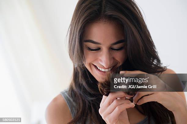 close up of woman admiring her hair - cabello humano fotografías e imágenes de stock