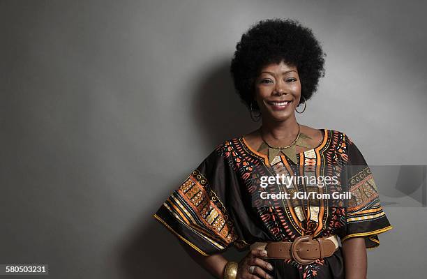 african american woman smiling with hand on hip - african tradition stock pictures, royalty-free photos & images