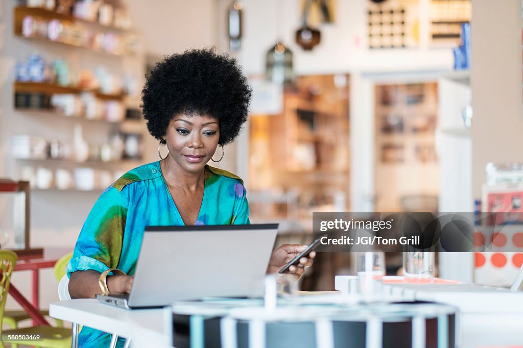 African American business owner using laptop in store