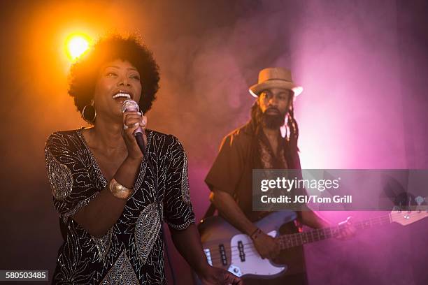 singer and guitarist performing on stage - black hair band stock pictures, royalty-free photos & images