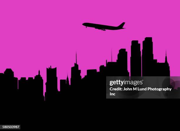 silhouette of airplane flying over city skyline - city night stock illustrations