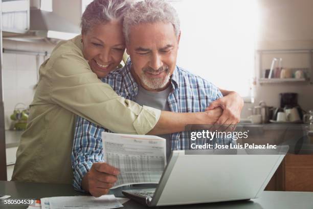 hispanic couple paying bills on laptop - pay day stock pictures, royalty-free photos & images