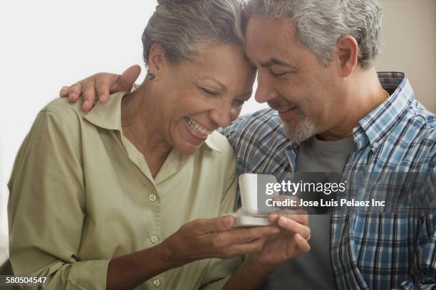 hispanic man proposing to girlfriend - couple jewelry stockfoto's en -beelden