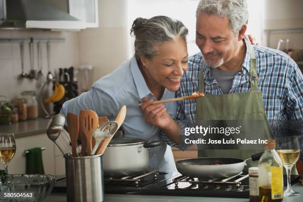 Hispanic couple cooking in kitchen