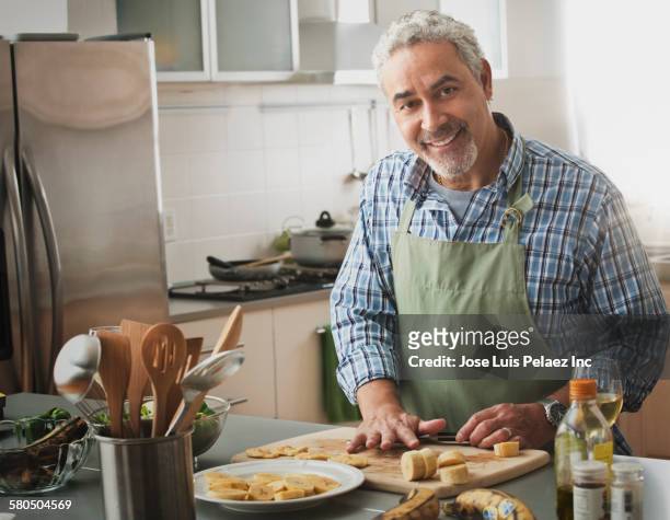 hispanic man cooking in kitchen - kitchen apron stock pictures, royalty-free photos & images