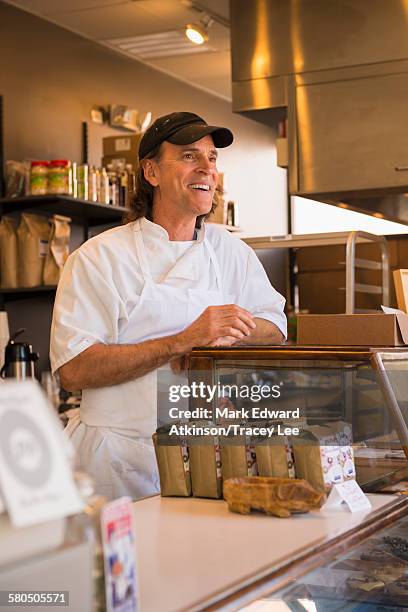 caucasian baker working in bakery - baker hat stock pictures, royalty-free photos & images