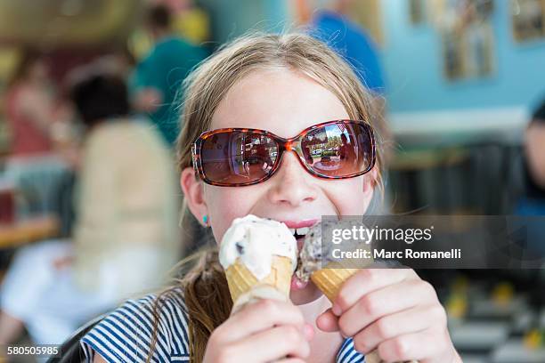 caucasian girl eating two ice cream cones - holding two things foto e immagini stock