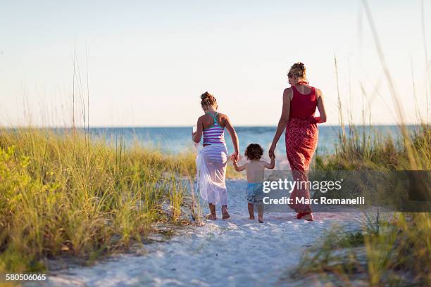 caucasian mother and children walking on beach - beach florida family stockfoto's en -beelden