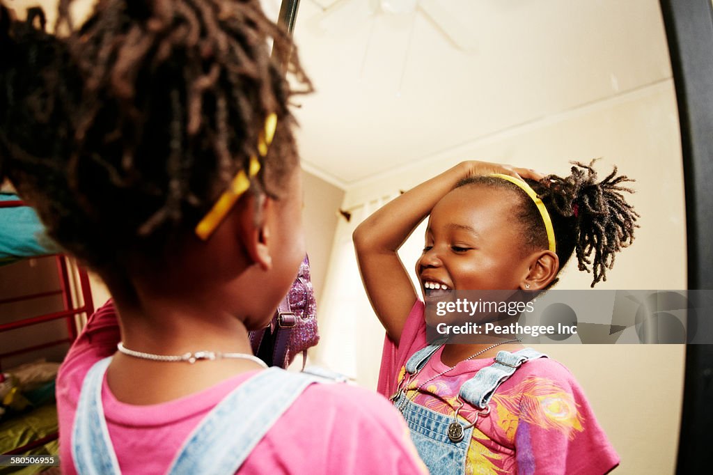 Black girl admiring herself in mirror