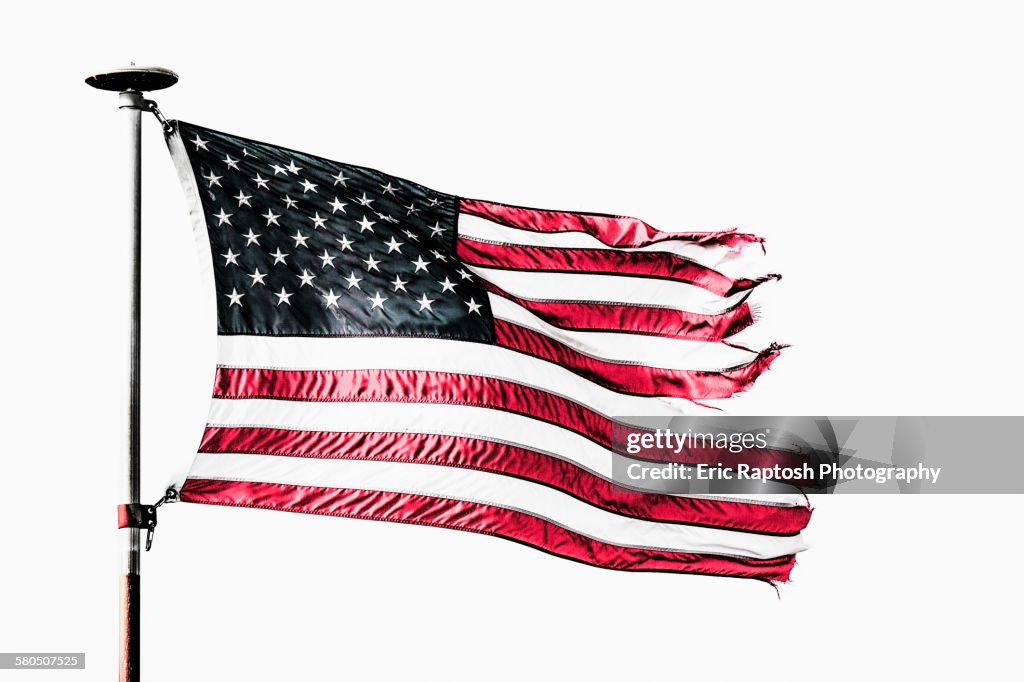 Tattered American flag flying from flagpole