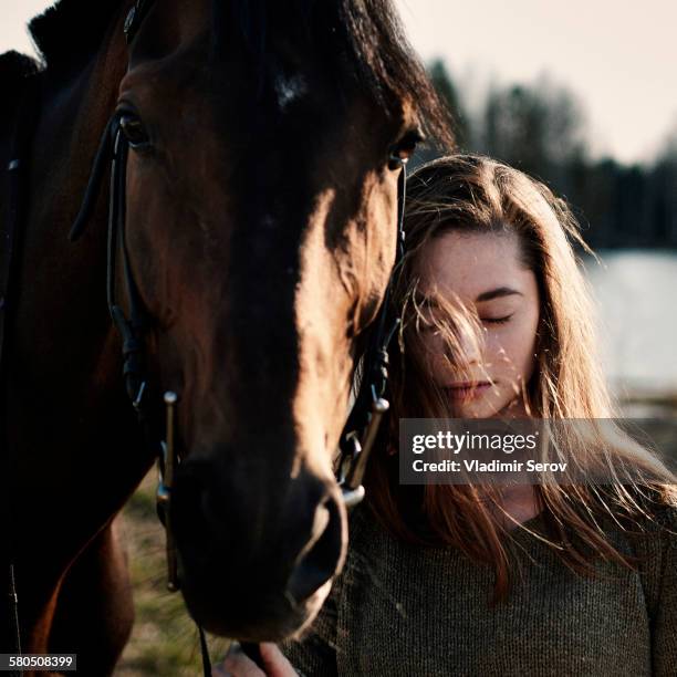 caucasian woman walking with horse in field - 1 woman 1 horse stock-fotos und bilder