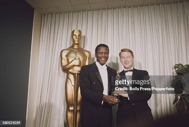 American actor Sidney Poitier, left, presents the Academy Award, or Oscar, for Best Director to Mike Nichols for his film The Graduate at the 40th...
