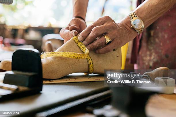 shoemaker measuring wooden shoe form - shoe repair stockfoto's en -beelden