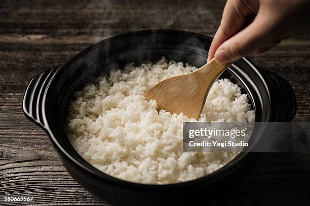 steamed rice served in earthen pot - wooden spoon imagens e fotografias de stock