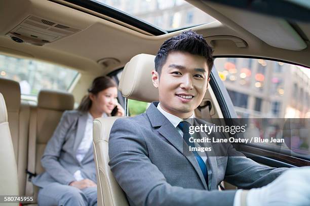 chauffeur driving car for a businesswoman - driver's seat stock pictures, royalty-free photos & images