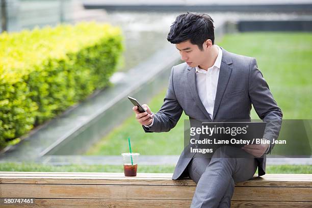 young businessman working with laptop outdoors - rietje los stockfoto's en -beelden