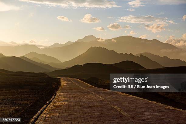 road and mountain range in gansu province, china - zhangye photos et images de collection