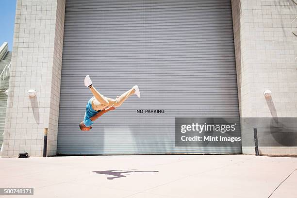 young man somersaulting, a parcour runner, - le parkour fotografías e imágenes de stock