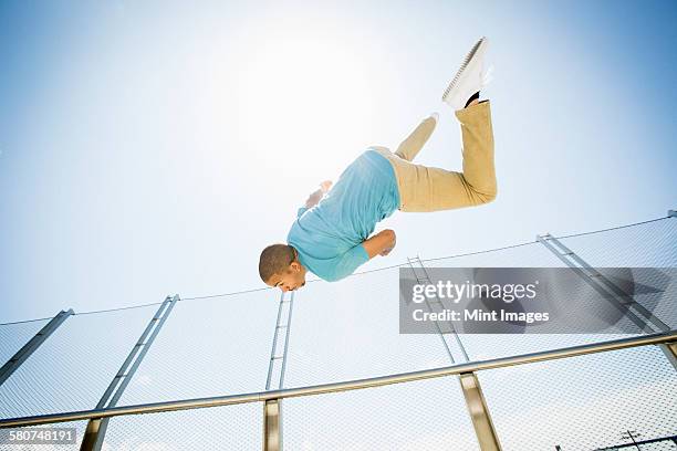 young man somersaulting on a bridge. - back flip bridge stock pictures, royalty-free photos & images